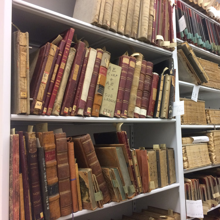 Shelves filled with old, leather-bound books and archival volumes.